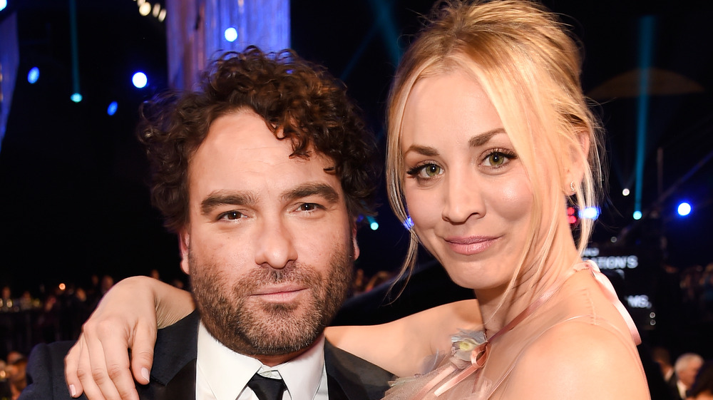 Kaley Coco posing with arms around Johnny Galecki