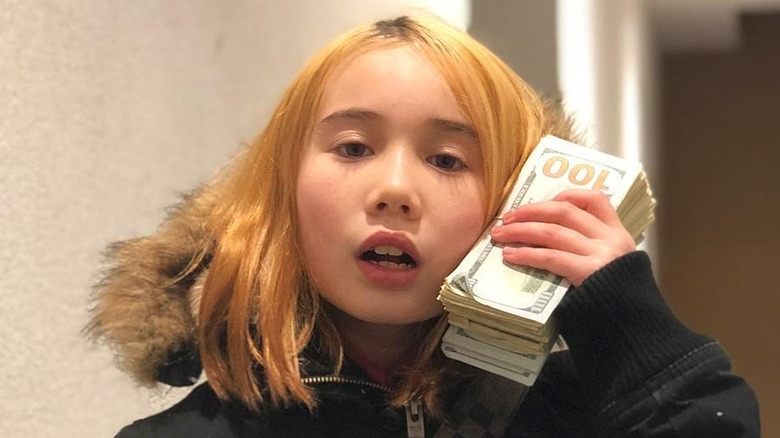 Lil Tay holding a stack of money