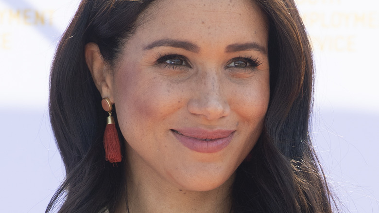 Meghan Markle smiling and looking to the side