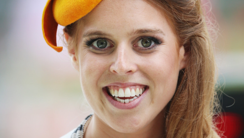 Princess Beatrice smiling in an orange hat 
