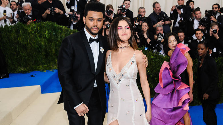 The Weeknd and Selena Gomez pose on stairs