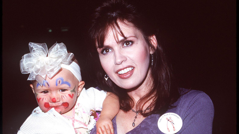 Marie Osmond holds one of her daughters as a baby.