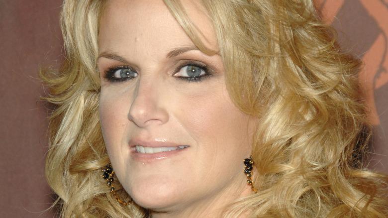 Trisha Yearwood smiles slightly fo the camera as she poses at an event