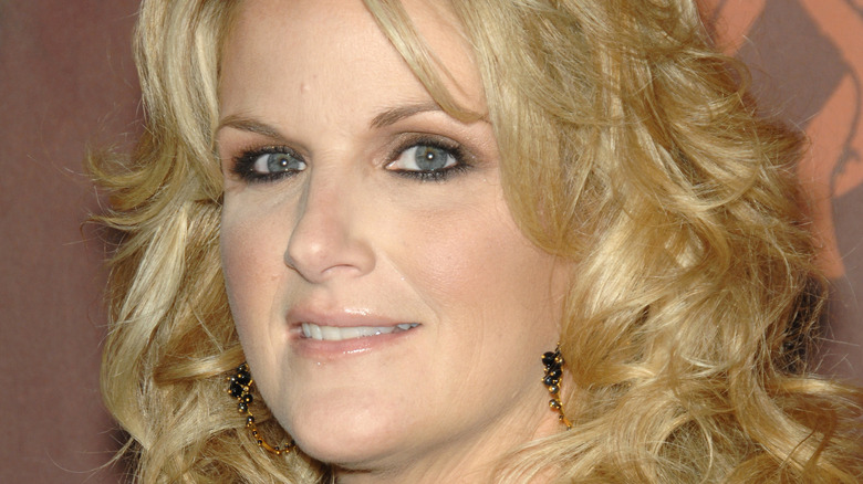 Trisha Yearwood smiles slightly fo the camera as she poses at an event