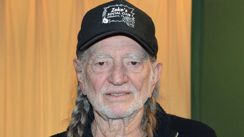 Willie Nelson holding his 2012 autobiography.