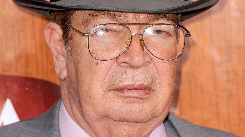 Richard Harrison scowling in a hat and glasses