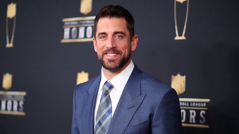 Aaron Rodgers posing in a suit