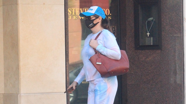 Stephanie Courtney with a mask and big purse