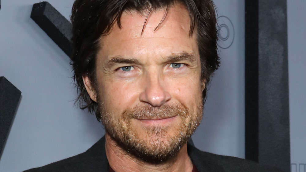 A bearded Jason Bateman smirking 