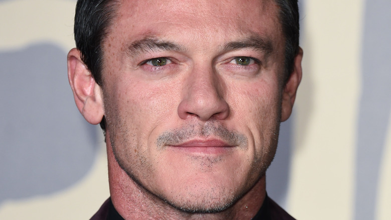 Luke Evans poses at event