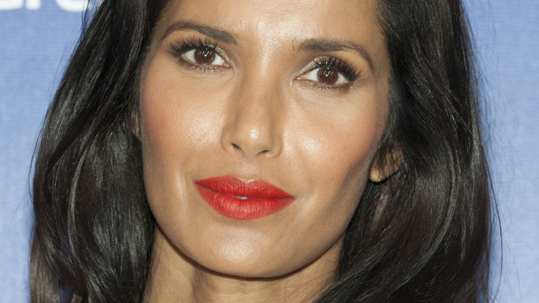 Padma Lakshmi posing with slight smile and red lipstick