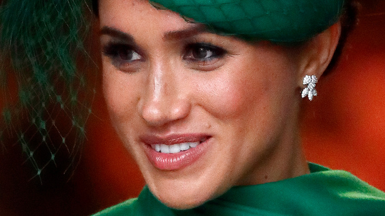 Meghan Markle smiling and looking to the side