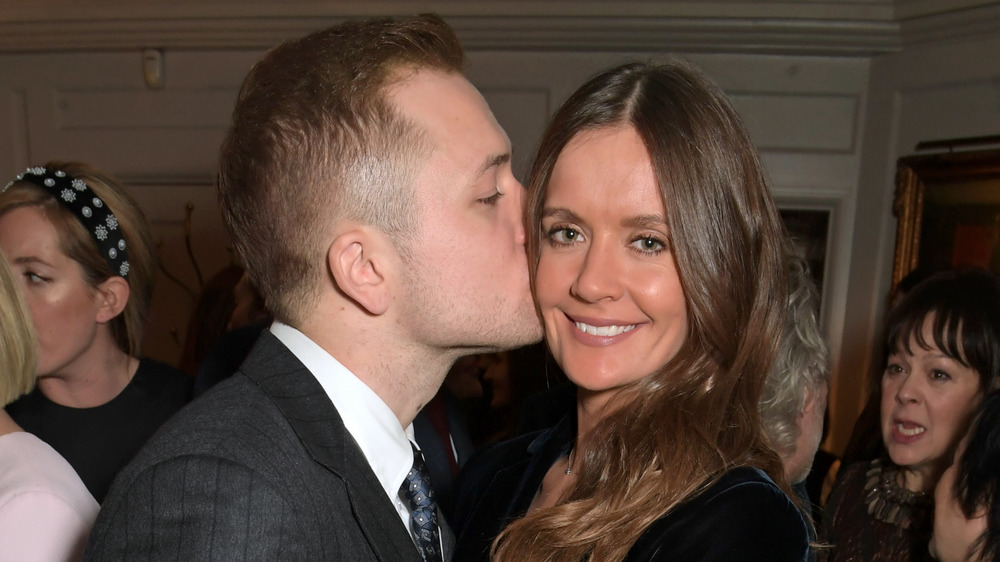 Taron Egerton kissing Emily Thomas on the cheek at a pre-BAFTA party