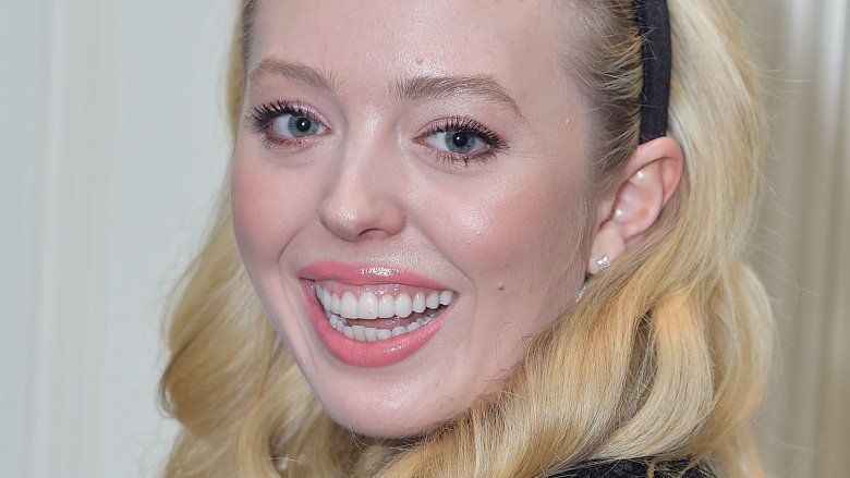 Tiffany Trump smiling big, wearing a plaid outfit and black headband