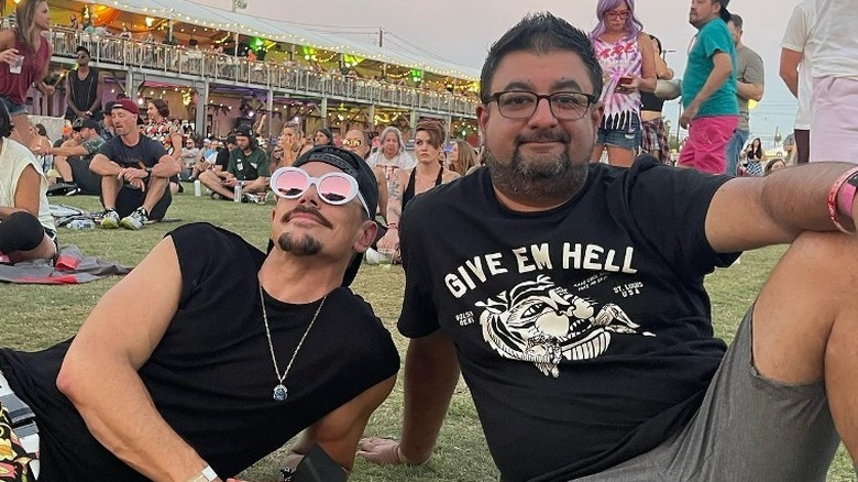 Tom Sandoval and Ali Rafiq sitting on grass