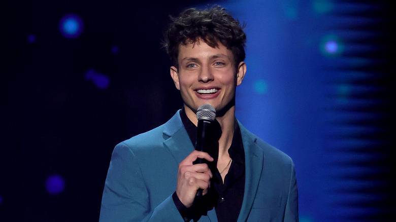 Matt Rife smiling holding a microphone