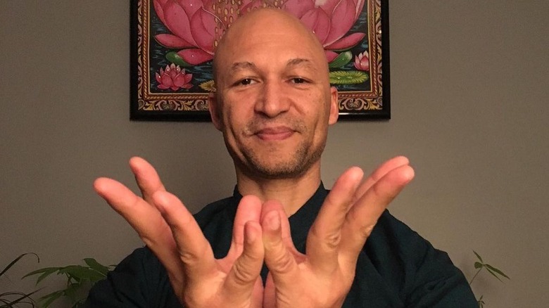 Joshua Bee Alafia poses with his hands