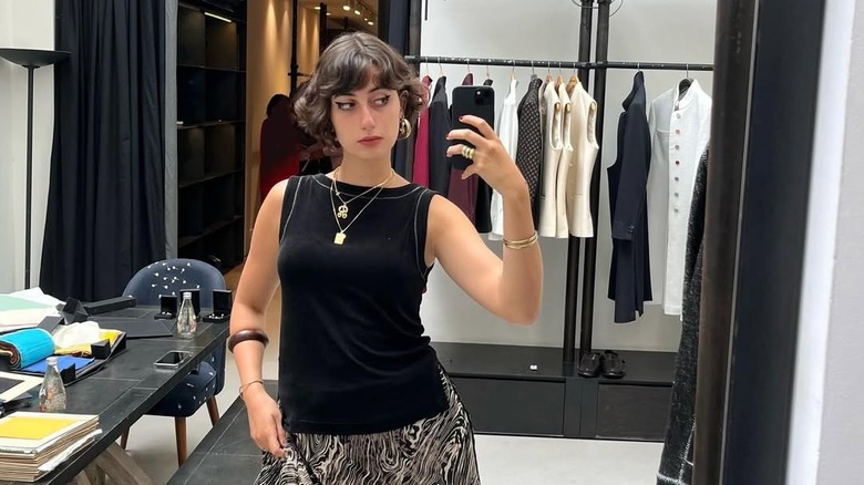 Rama Duwaji posing near clothing rack