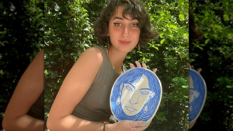 Rama Duwaji posing in front of leafy plants