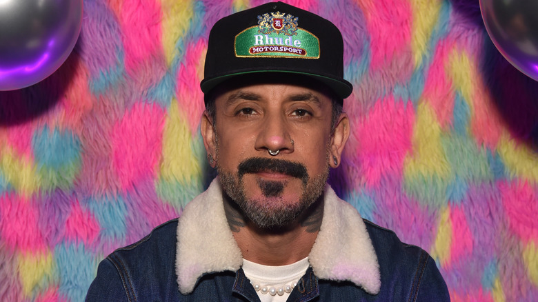 AJ McLean smiling in a baseball cap