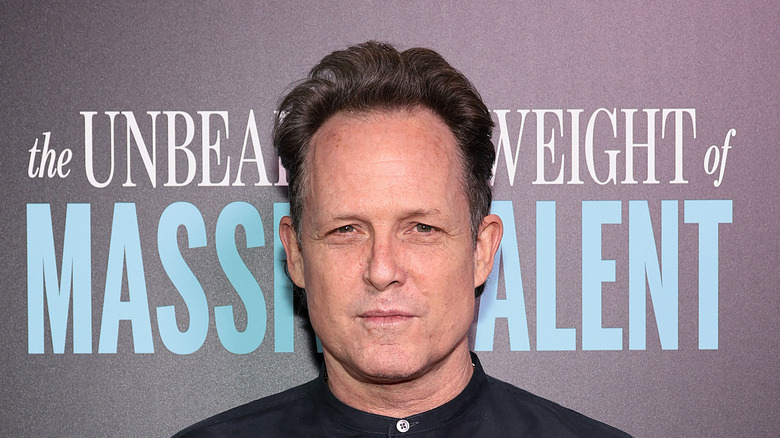 Dean Winters in black collarless shirt