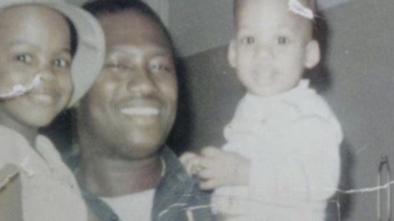 A young Chris Rock smiles with his dad and sibling