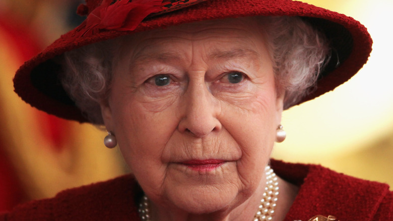 Queen Elizabeth wearing a red hat