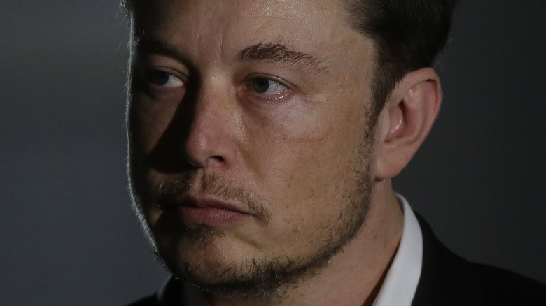 Elon Musk in a dimly lit room