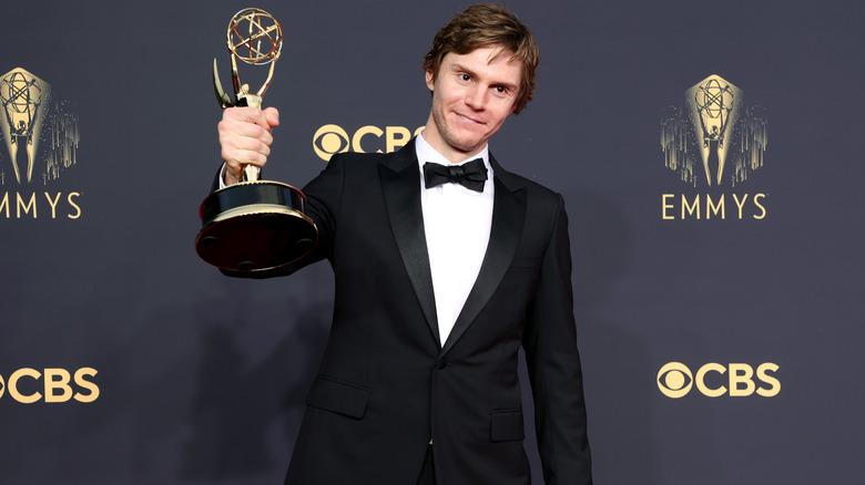 Evan Peters posing with an award