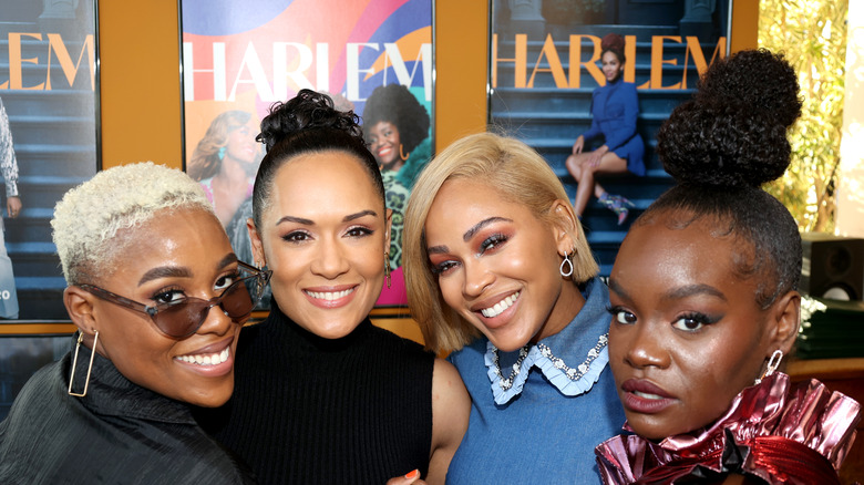The cast of Harlem smiling at an event