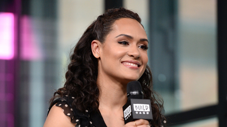 Grace Byers sitting down holding a microphone