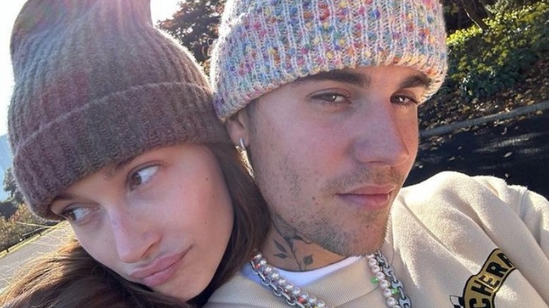 Justin and Hailey Bieber take a selfie wearing woolly hats 