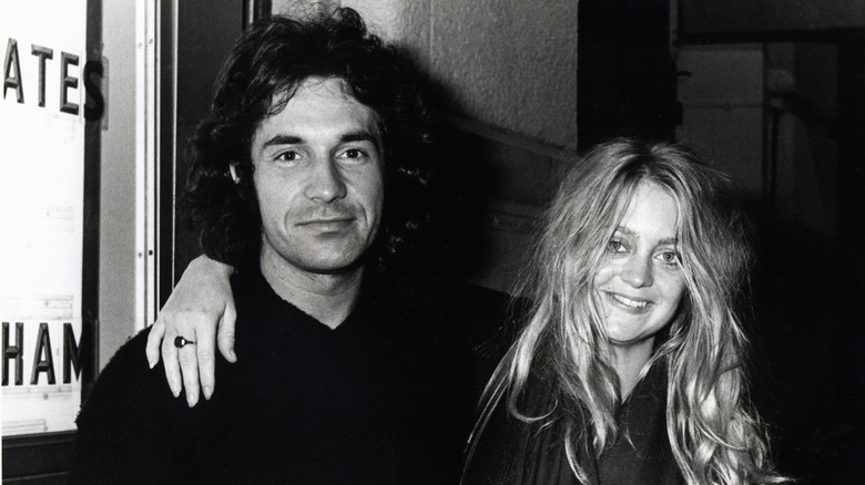 Old photo of Goldie Hawn with her arm around Bill Hudson's shoulders.