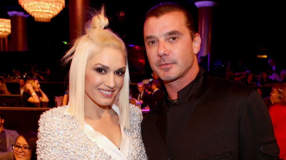 A smiling Gwen Stefani and a serious-looking Gavin Rossdale posing at an event a year before their divorce