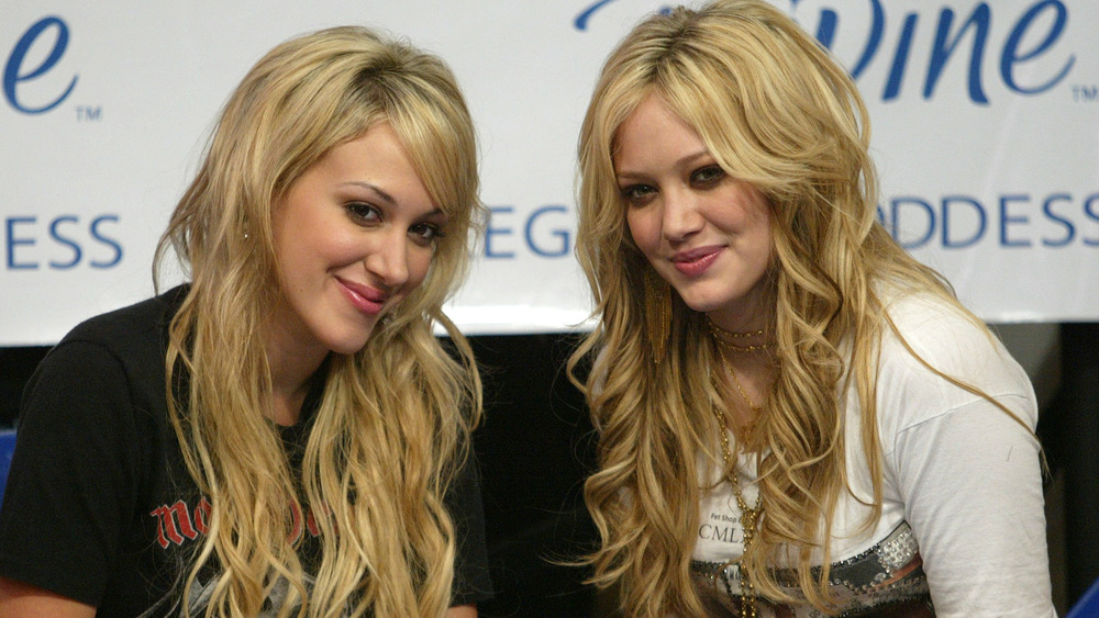 Hilary and Haylie Duff seated and smiling at an event