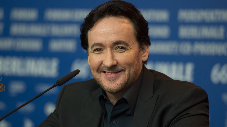 John Cusack at a press event in a suit