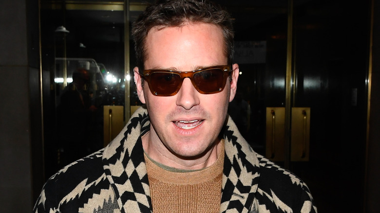 Armie Hammer outside a building interacting with press