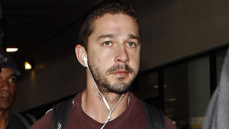 Shia LaBeouf walking with headphones in