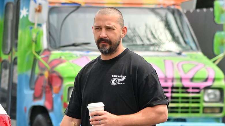 Shia LaBeouf walking with a coffee cup