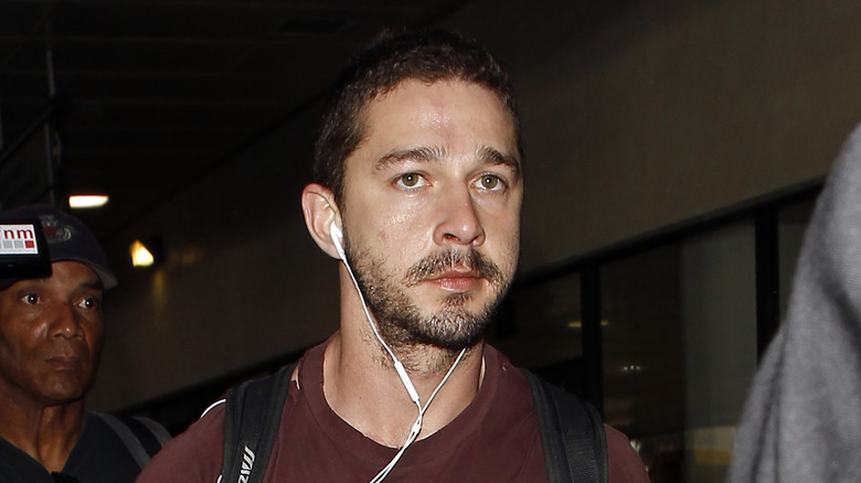 Shia LaBeouf walking with headphones in