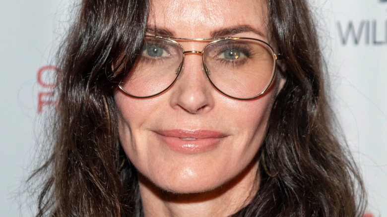 Courteney Cox on red carpet wearing glasses