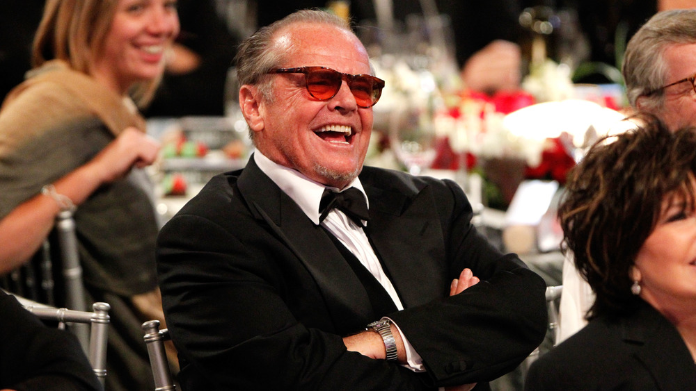 Jack Nicholson, seated and laughing