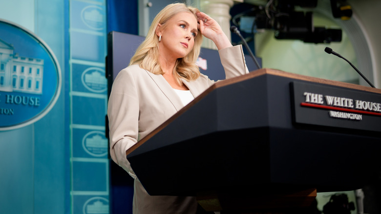 Karoline Leavitt smooths her hair during a White House press briefing.