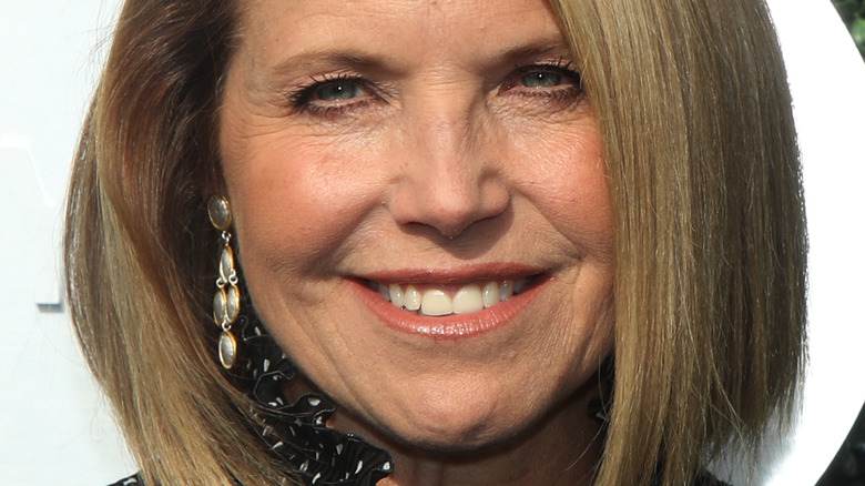 Katie Couric smiles while walking the red carpet