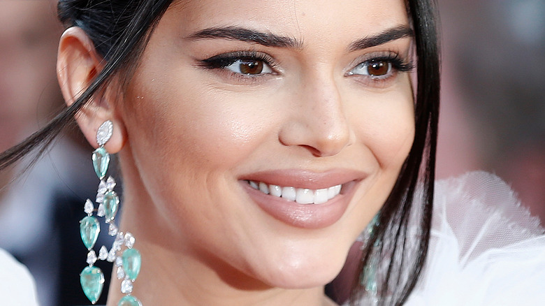 Kendall Jenner on the red carpet smiing to the side with long earrings