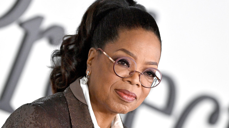 Oprah Winfrey poses in round rose glasses