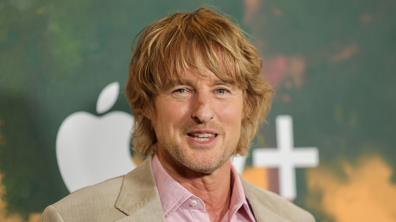 Up-close photo of Owen Wilson in a pink shirt and tan corduroy blazer.