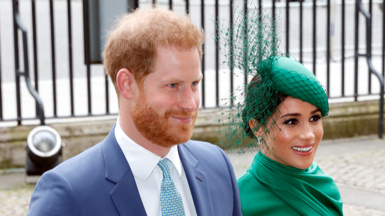 Prince Harry and Meghan Markle smiling and walking