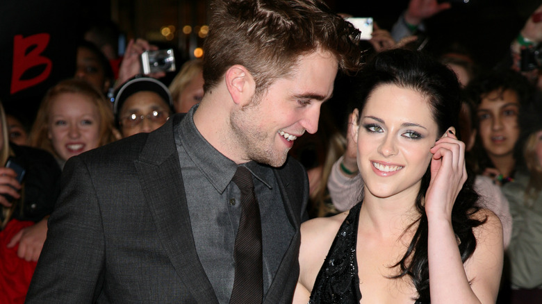 Robert Pattinson smiling at Kristen Stewart on red carpet 