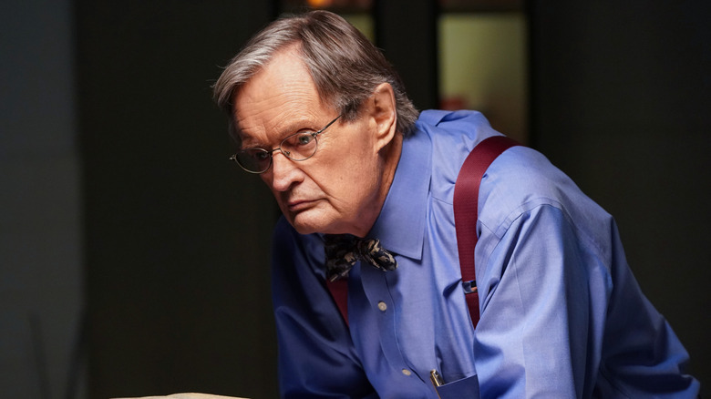 David McCallum leaning down with a stern look in a scene from NCIS